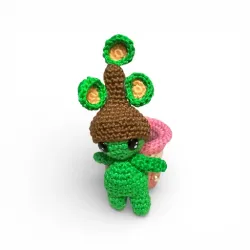 Petite figurine verte en crochet, en forme de plante, en dehors de son pot amovible.