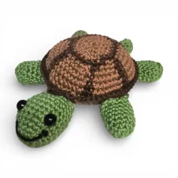 Petite tortue verte et marron crochetée à la main, vue de face.