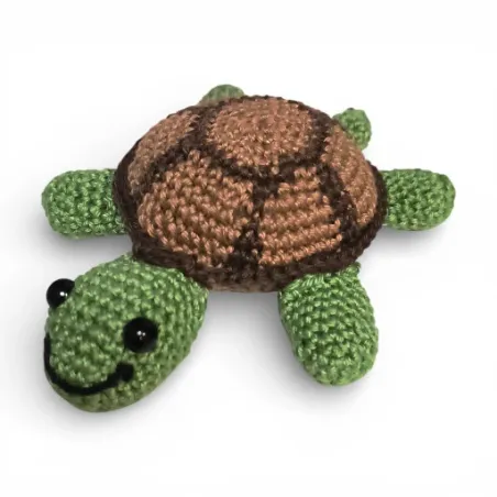 Petite tortue verte et marron crochetée à la main, vue de face.