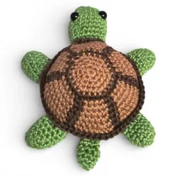Petite tortue verte et marron crochetée à la main, vue de dessus.