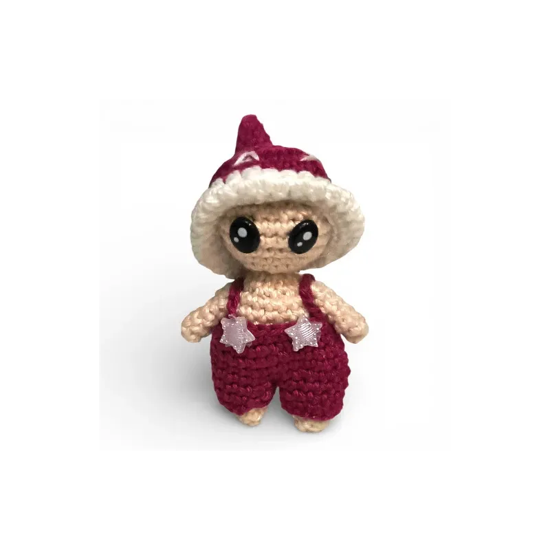 Petite figurine champignon Bolet en crochet bordeaux avec salopette et étoiles.