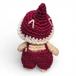 Petite figurine champignon Bolet en crochet bordeaux avec salopette et étoiles. Vue de dos.