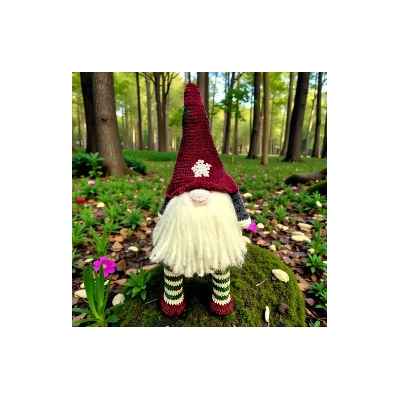 Grand gnome Hector en crochet assis dans la forêt avec bonnet bordeaux et longues jambes rayées.