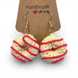 Boucles d'oreilles donuts artisanales présentées sur leur support porte-bijoux en kraft.