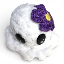 Mini pieuvre blanche en fil chenille avec jolie fleur violette crochetée, vue de dessus.
