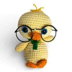 Poussin artisanal duveteux jaune avec petites lunettes rondes, décoration de Pâques originale.