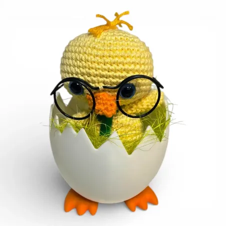 Poussin au crochet avec lunettes et nœud papillon vert dans un œuf sur pieds imprimé en 3D.